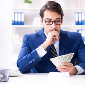 Salario mínimo - Hombre vestido de traje azul con dinero en la mano